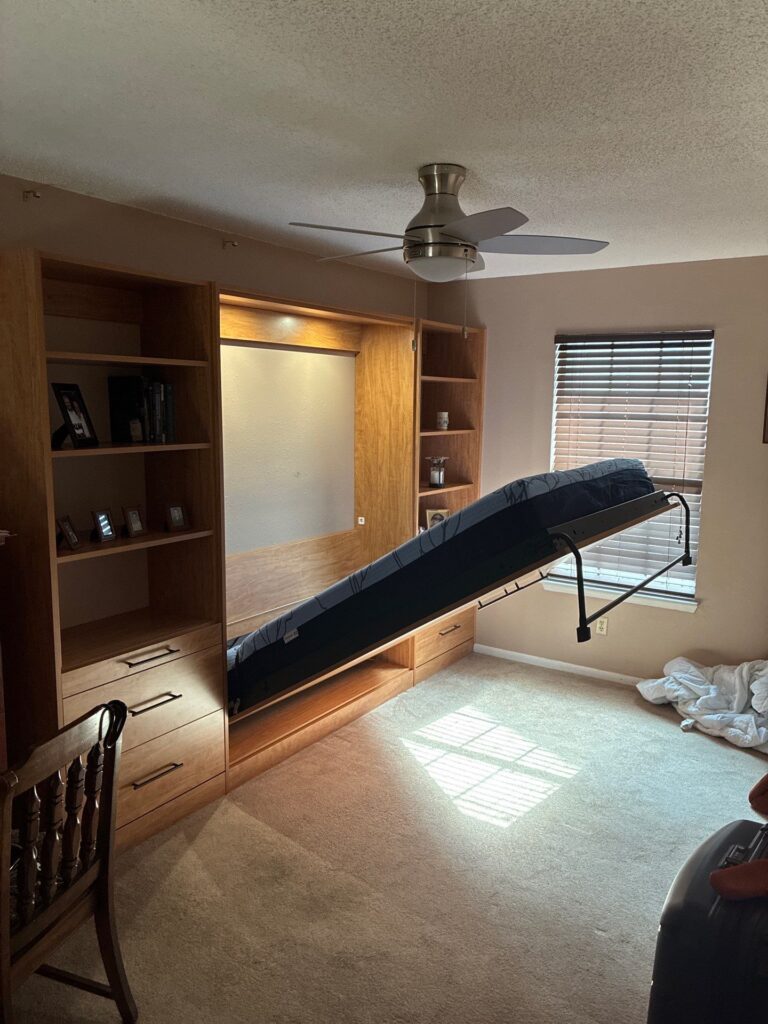 Custom murphy bed in Pensacola bedroom showing space-saving design with bed pulled down
