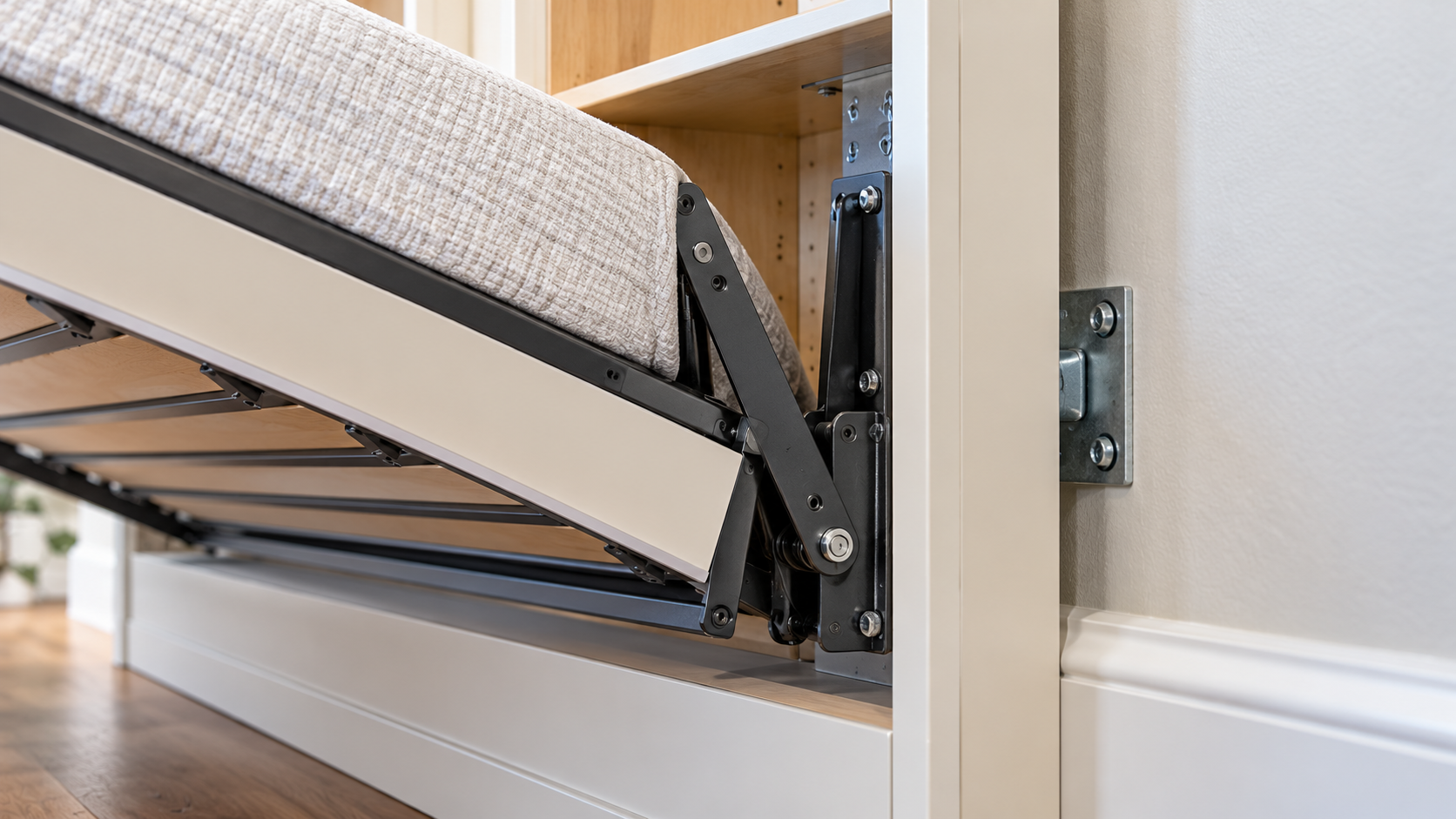 Close-up of a Murphy bed pivot mechanism and the cabinet bracket fastened at the wall.